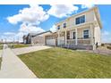 Charming exterior view of a two-story home with a welcoming front porch and well-maintained lawn at 1850 Sawtooth Mountain Dr, Berthoud, CO 80513