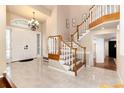 Inviting foyer with tile floors, a grand staircase, and an elegant chandelier at 8047 S Fairfax Ct, Centennial, CO 80122