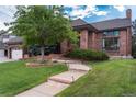 Beautiful brick home with a curved walkway and manicured landscaping at 8047 S Fairfax Ct, Centennial, CO 80122