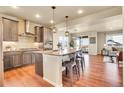 Modern kitchen with stainless steel appliances, large island with seating, and stylish pendant lighting at 16360 Paris Way, Brighton, CO 80602