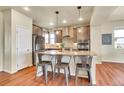 Well-lit kitchen features stainless steel appliances, an island with seating, and stylish modern pendant lighting at 16360 Paris Way, Brighton, CO 80602