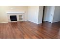 Bright living room features a fireplace, wood floors, and neutral paint colors at 16360 Paris Way, Brighton, CO 80602