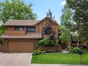 Lovely two-story home featuring a well-maintained lawn, mature trees, and an attached two-car garage at 5860 W Atlantic Dr, Lakewood, CO 80227