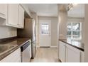 Bright kitchen featuring stainless steel appliances, white cabinets, and a door leading to the exterior at 7165 S Gaylord St # E09, Centennial, CO 80122