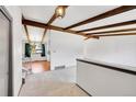 Bright living room with exposed beams, neutral carpet, and open floorplan that leads to the dining area at 3792 S Fenton Way, Denver, CO 80235