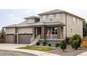 Charming two-story home featuring a welcoming front porch, three-car garage and manicured lawn at 15977 Red Bud Dr, Parker, CO 80134