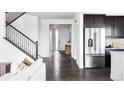 Bright foyer featuring dark wood floors, staircase with iron railing and stainless steel refrigerator at 15977 Red Bud Dr, Parker, CO 80134