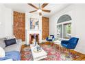 Cozy living room showcasing exposed brick, decorative fireplace, hardwood floors, and comfortable blue furniture at 2211 W 33Rd Ave, Denver, CO 80211