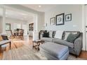 Open living space with hardwood floors, a modern sofa, and a view into the dining room at 493 S Lincoln St, Denver, CO 80209