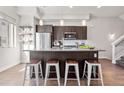 Modern kitchen with an island, stainless steel appliances, dark wood cabinets, and hardwood floors at 2321 Eliot St, Denver, CO 80211