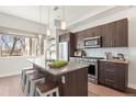 Bright kitchen with island seating, stainless steel appliances, pendant lighting, and hardwood floors at 2321 Eliot St, Denver, CO 80211