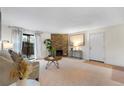 Cozy living room featuring stone fireplace, neutral carpet, and sliding glass door to balcony at 201 Wright St # 106, Lakewood, CO 80228