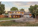 Expansive backyard featuring a large deck, stone fire pit, and mature landscaping at 13055 E Dakota Ave, Aurora, CO 80012
