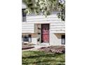A charming home front showcases a decorative red door, brick accents, and curb appeal at 13055 E Dakota Ave, Aurora, CO 80012