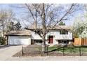 An inviting front exterior showcases a charming two-story home with a well-maintained yard and beautiful tree at 13055 E Dakota Ave, Aurora, CO 80012