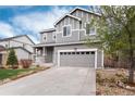 Gray two-story home featuring a large driveway and a well-manicured lawn at 7844 Grady Cir, Castle Rock, CO 80108