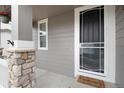 Close-up of the front entrance with stone pillar, welcome mat and storm door at 7844 Grady Cir, Castle Rock, CO 80108