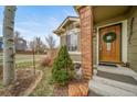 Inviting home featuring a striking front door, brickwork, and lush garden elements at 16309 Hedgeway Dr, Parker, CO 80134