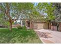 Charming two-story home with a well-maintained lawn, mature trees, and a two-car garage at 16309 Hedgeway Dr, Parker, CO 80134