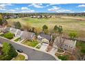 Aerial view of a neighborhood highlighting homes, green spaces, and the surrounding landscape under a blue sky at 6340 E Costilla Pl, Centennial, CO 80112