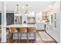 Bright kitchen features a marble island with seating, white cabinets, and stainless steel appliances at 6340 E Costilla Pl, Centennial, CO 80112