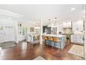 Open-concept kitchen with large island, pendant lighting, and hardwood floors adjoining the dining area at 6340 E Costilla Pl, Centennial, CO 80112
