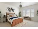 Neutral bedroom featuring natural light, white walls, a decorative star chandelier, and a seating bench at 19834 W 56Th Pl, Golden, CO 80403