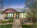 Inviting home showcasing a cozy front porch, stone detailing, and manicured landscaping at 19834 W 56Th Pl, Golden, CO 80403