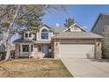 Inviting two-story home with a brick facade, a blue front door, and an attached two-car garage at 6651 Yale Dr, Highlands Ranch, CO 80130