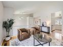 Second-floor landing with hardwood floors, a cozy seating area with two brown armchairs and neutral decor at 145 S Buchanan Ave, Louisville, CO 80027