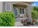 Cozy front porch adorned with beautiful flower pots and a white bench, creating a welcoming entrance at 12054 E Lake Cir, Greenwood Village, CO 80111