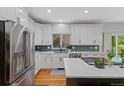 A bright, modern kitchen with stainless steel appliances and an island with white countertops at 12054 E Lake Cir, Greenwood Village, CO 80111