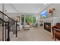 Spacious living room with a fireplace, large windows, and comfortable seating, perfect for relaxation at 12054 E Lake Cir, Greenwood Village, CO 80111