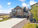 Inviting two-story house features a stone facade, a three-car garage, and manicured landscaping at 3038 Blithe Pt, Castle Rock, CO 80108