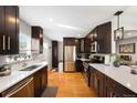 Updated kitchen featuring stainless steel appliances, dark cabinetry, light countertops and hardwood flooring at 5125 Umatilla St, Denver, CO 80221