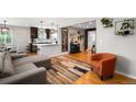 Open-concept living space with hardwood floors, modern furnishings, and seamless flow to the kitchen and dining area at 5125 Umatilla St, Denver, CO 80221