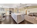 Modern kitchen featuring a large island with countertop seating, custom cabinets, and stainless-steel appliances at 2460 Eileen Way, Parker, CO 80138