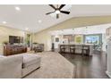 Spacious living room with a vaulted ceiling, a skylight, hardwood floors, and a seamless flow to the kitchen area at 2460 Eileen Way, Parker, CO 80138