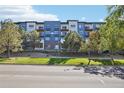 Contemporary apartment building with balconies, landscaping, and street view at 487 Interlocken Blvd # 307, Broomfield, CO 80021