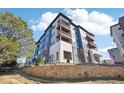 Modern apartment building with multiple balconies, set against a blue sky and stone wall at 487 Interlocken Blvd # 307, Broomfield, CO 80021