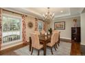 Inviting dining room with chandelier, wooden table, and chairs, bathed in natural light from a large window at 7076 S Niagara Ct, Centennial, CO 80112