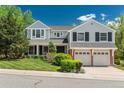 Beautiful two-story house with a well-maintained lawn and attached two-car garage, framed by lush greenery at 7076 S Niagara Ct, Centennial, CO 80112
