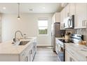 Modern kitchen features stainless steel appliances, bright countertops, and ample natural light at 1208 Quitman St # 305, Denver, CO 80204