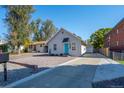 House exterior showcasing a gravel driveway and mature trees at 1330 Ammons St, Lakewood, CO 80214