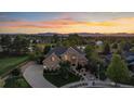 Stunning aerial view of a two-story home with landscaped yard against the backdrop of a colorful sunset and mountain range at 9375 Webster Way, Westminster, CO 80021