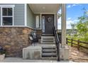 Inviting front porch with charming decor, stone accents, welcome signage and steps leading to a covered entrance at 3871 Starry Night Loop, Castle Rock, CO 80109