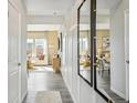 Bright hallway featuring modern decor, hardwood floors, and an open view to the living and dining areas at 2153 Flower Blossom Ave, Brighton, CO 80601
