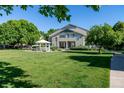 Green townhome featuring a well-kept lawn, white gazebo, and mature trees in a peaceful setting at 930 Button Rock Dr # 28, Longmont, CO 80504