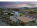 Aerial view of horse property with fencing, barn, riding arena, and lush landscape at sunset at 810 N Perry Park Rd, Sedalia, CO 80135
