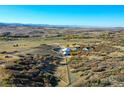 Aerial view of horse property with a barn, riding arena, and home on a sprawling landscape at 810 N Perry Park Rd, Sedalia, CO 80135